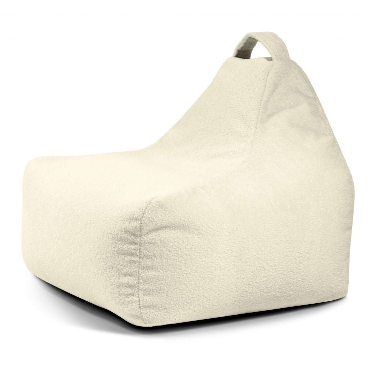 El Bean bag Game Teddy es un sillón de tela suave de color crema con respaldo alto y asa superior, ideal como puff ergonómico, que aquí se muestra sobre fondo blanco.