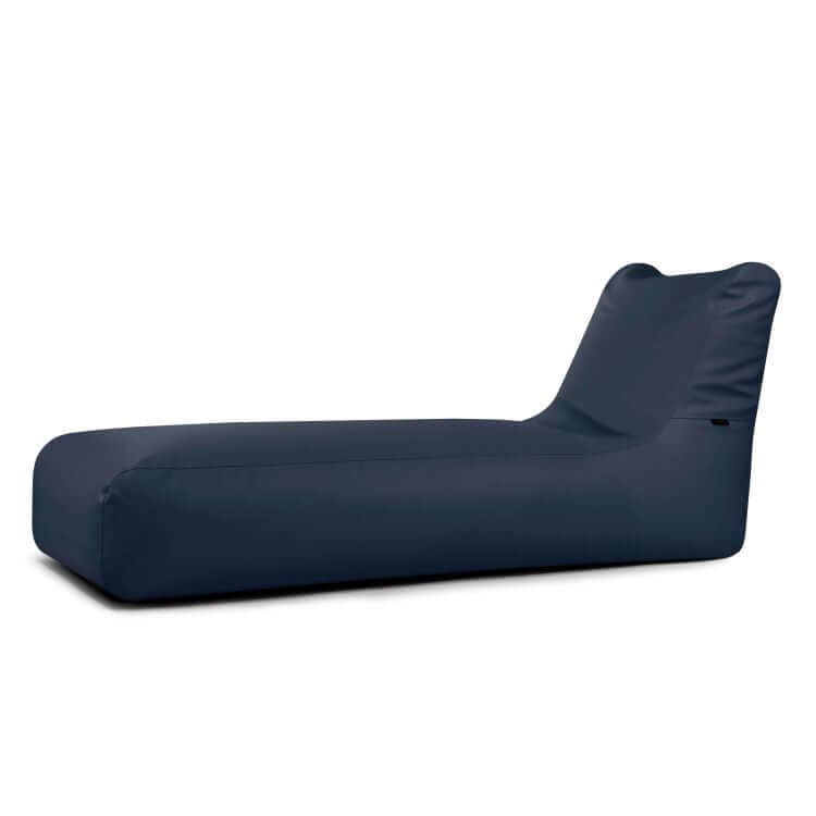 El Bean Bag Sunbed Outside, diseñado para su uso en exteriores, presenta un asiento bajo y un respaldo en ángulo en tejido azul marino, que proporciona la relajada comodidad de una chaise longue. Se presenta sobre un fondo blanco liso.