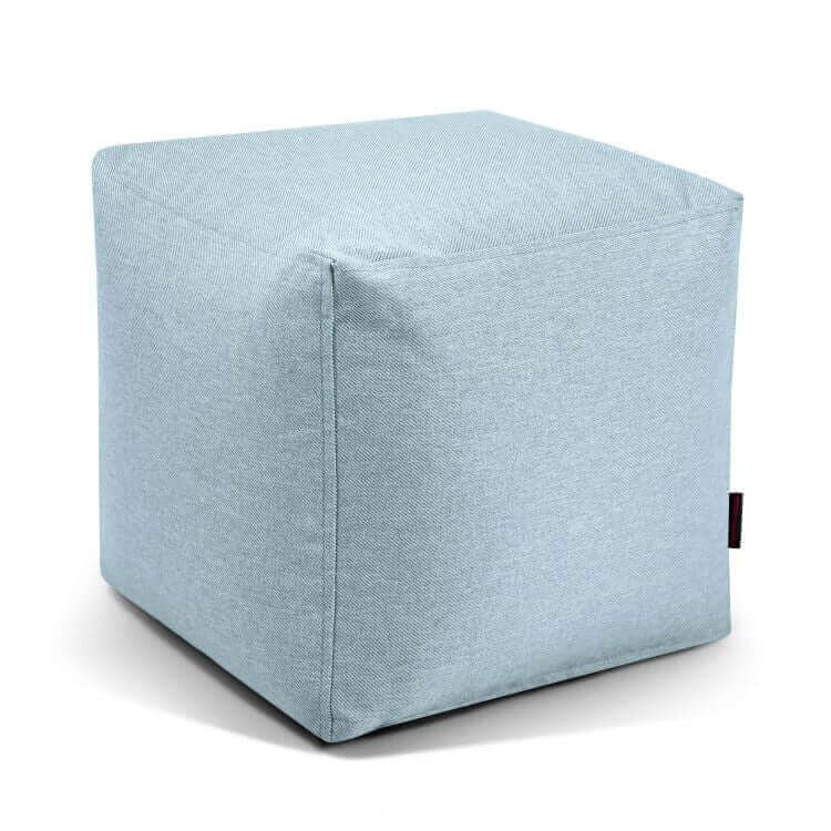 ¡El puf Up! Riviera - uso exteriores es un puf azul claro con forma de cubo y costuras visibles. Proporciona comodidad y estilo como asiento versátil para cualquier espacio, y se representa sobre un fondo blanco.