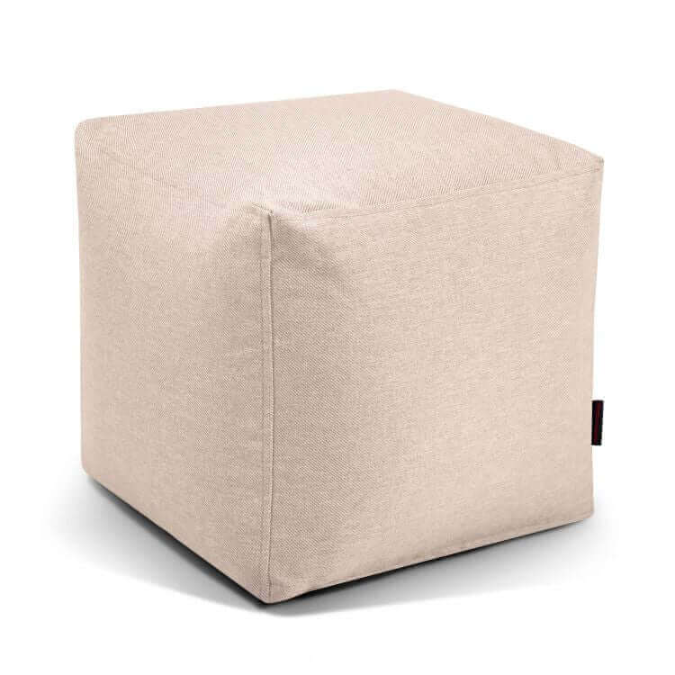 ¡El puf Up! Riviera - uso exterior es una otomana cúbica de tela beige con costuras visibles, que ofrece un asiento versátil para cualquier espacio. Se muestra sobre fondo blanco.