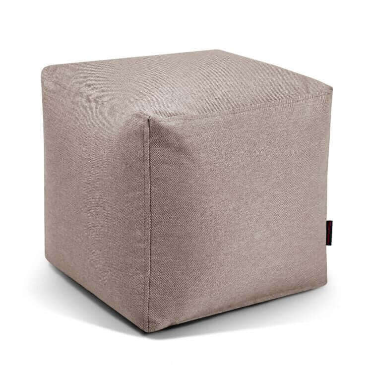 ¡El puf Up! Riviera - uso exterior es una otomana ergonómica en forma de cubo, de color beige, tapizada en tela, con costuras visibles y asiento versátil, mostrada sobre fondo blanco.