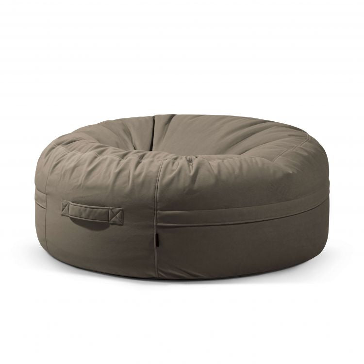 Un Puff gigante redondo beige oscuro de terciopelo 135×135×50 cm - moderno - salón - ROLL 135 BARCELONA con asa lateral se muestra sobre un fondo blanco liso.
