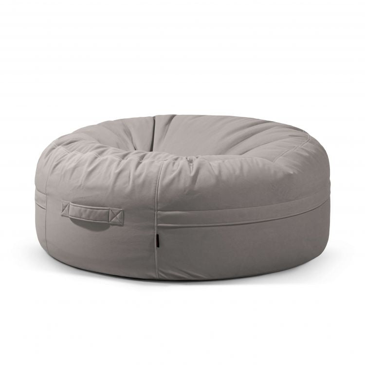 El Puff gigante redondo de terciopelo 135×135×50 cm ROLL 135 BARCELONA, moderno y ergonómico, con asa lateral, aparece en color gris claro sobre un fondo blanco.