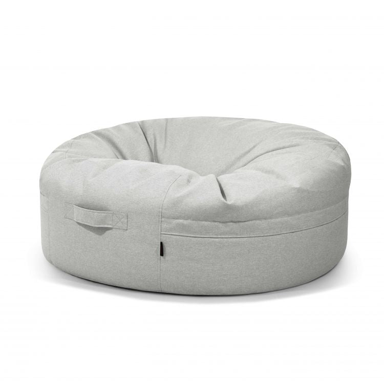 El Bean Bag Roll 135 Riviera - uso exterior es un bean bag redondo de color gris claro con asa lateral, perfecto como asiento informal y representado sobre un fondo blanco liso.