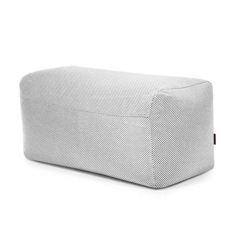 El Pouf Plus 100 Capri - uso exterior es un puf rectangular de color gris, con bordes redondeados y una sutil textura, que proporciona un soporte ergonómico. Se muestra sobre fondo blanco.