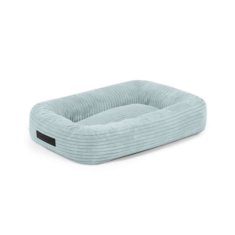 CAMA PARA PERROS 55 ONDAS azul claro: cama para perro de terciopelo acanalado (55×45×16 cm) con laterales elevados y una base suave y acolchada, perfecta como acogedor colchón para perros, expuesta sobre un fondo blanco liso.