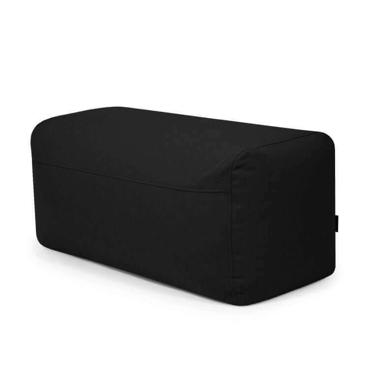 El Pouf Plus 100 Casa es un puf rectangular de tela negra con bordes redondeados, diseñado para su uso en exteriores, que se muestra sobre un fondo blanco.