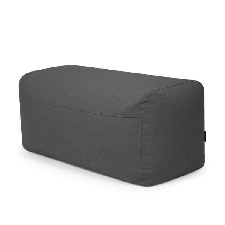 Sobre un fondo blanco, una otomana Pouf Plus 100 Casa - uso exteriores rectangular de tejido gris oscuro y bordes redondeados.