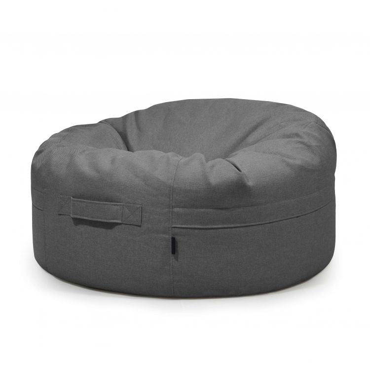 El Bean bag Roll 105 Riviera - uso exterior, un gran sillón redondo de color gris oscuro con un asa lateral, se asienta sobre un fondo blanco liso, perfecto para espacios exteriores con estilo.