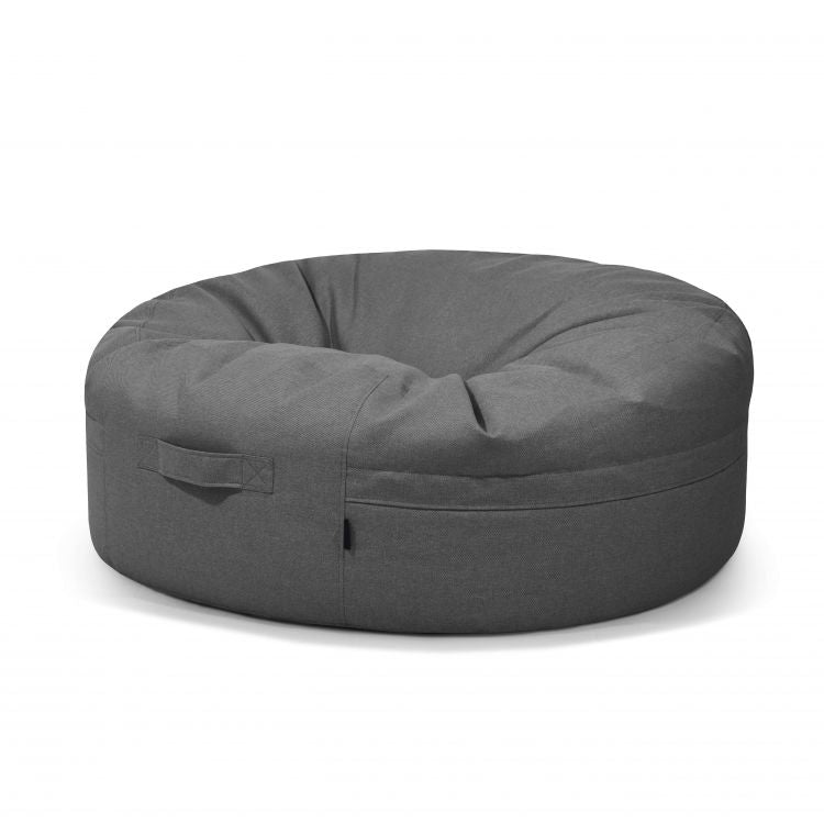 El Bean Bag Roll 135 Riviera - uso exteriores es un sillón redondo de puff bag gris oscuro con asa de tela, ideal como asiento informal, que se muestra sobre un fondo blanco liso.