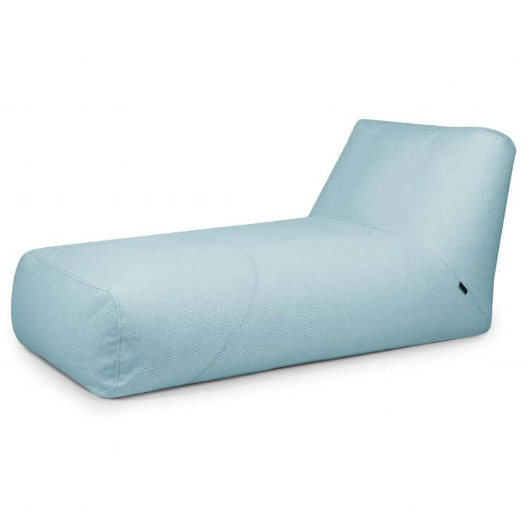 Bean Bag Tube 100 Daybed Dunes de color azul claro para uso en exteriores, con un perfil bajo, respaldo en ángulo y suave tapizado de tela, sobre un fondo blanco liso.