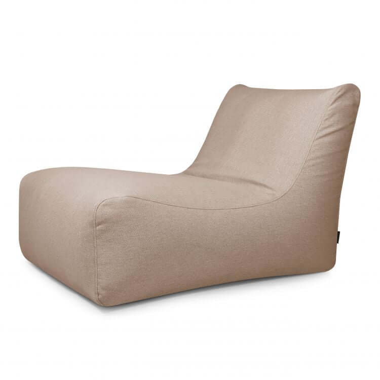 El Bean Bag Lounge 100 Dunes es un moderno sillón beige de perfil bajo con respaldo curvado y suave tapizado de tela para exteriores, que recuerda a un puff de gran formato, mostrado sobre un fondo blanco liso.