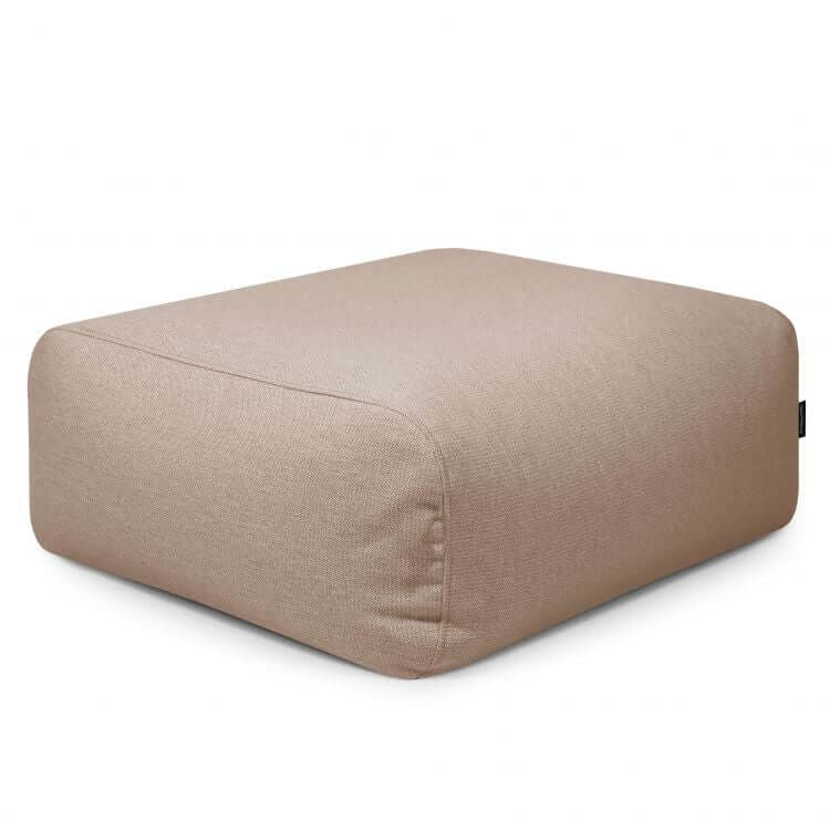 El Puf cuadrado TUBE 80 DUNES (85×85×38 cm), de tejido transpirable y lavable, es ideal para interior y exterior en ambientes modernos; su diseño moderno en color beige destaca sobre fondo blanco.