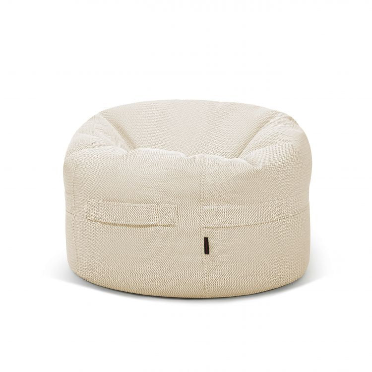 Sobre un fondo blanco liso se presenta un Bean Bag Roll 80 Canaria redondo, de color beige, para exteriores, fabricado en tela y con asa lateral.
