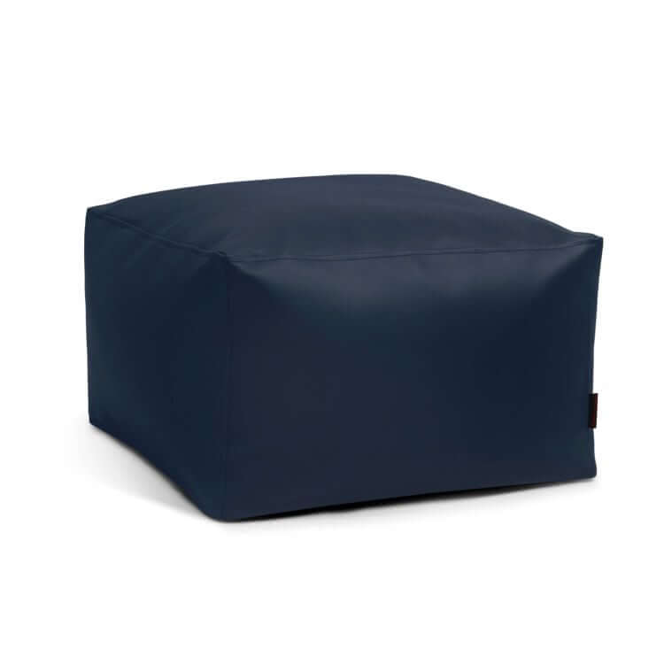 El Pouf Softbox Outside - uso exteriores es una otomana bean bag azul marino, de forma cuadrada y superficie lisa, que sirve de acento ergonómico y elegante sobre un fondo blanco.
