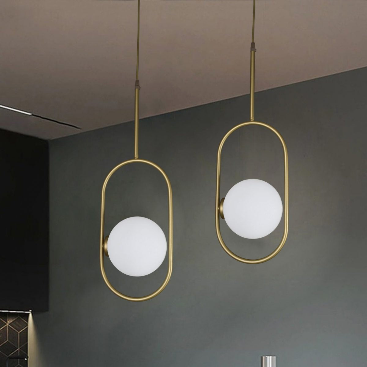 Dos lámparas colgantes Lámpara de Techo Colgante Moderna 3135-1C con marcos dorados y bombillas blancas redondas cuelgan sobre una barra de madera, añadiendo un toque industrial-chic a la habitación minimalista.