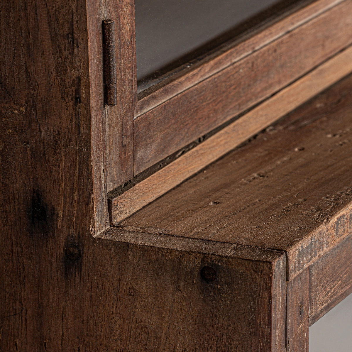 Primer plano de una esquina de la vitrina rústica en madera reciclada Jekye, que muestra la veta, la carpintería y la textura de la madera de mango reciclada envejecida para un ambiente acogedor.