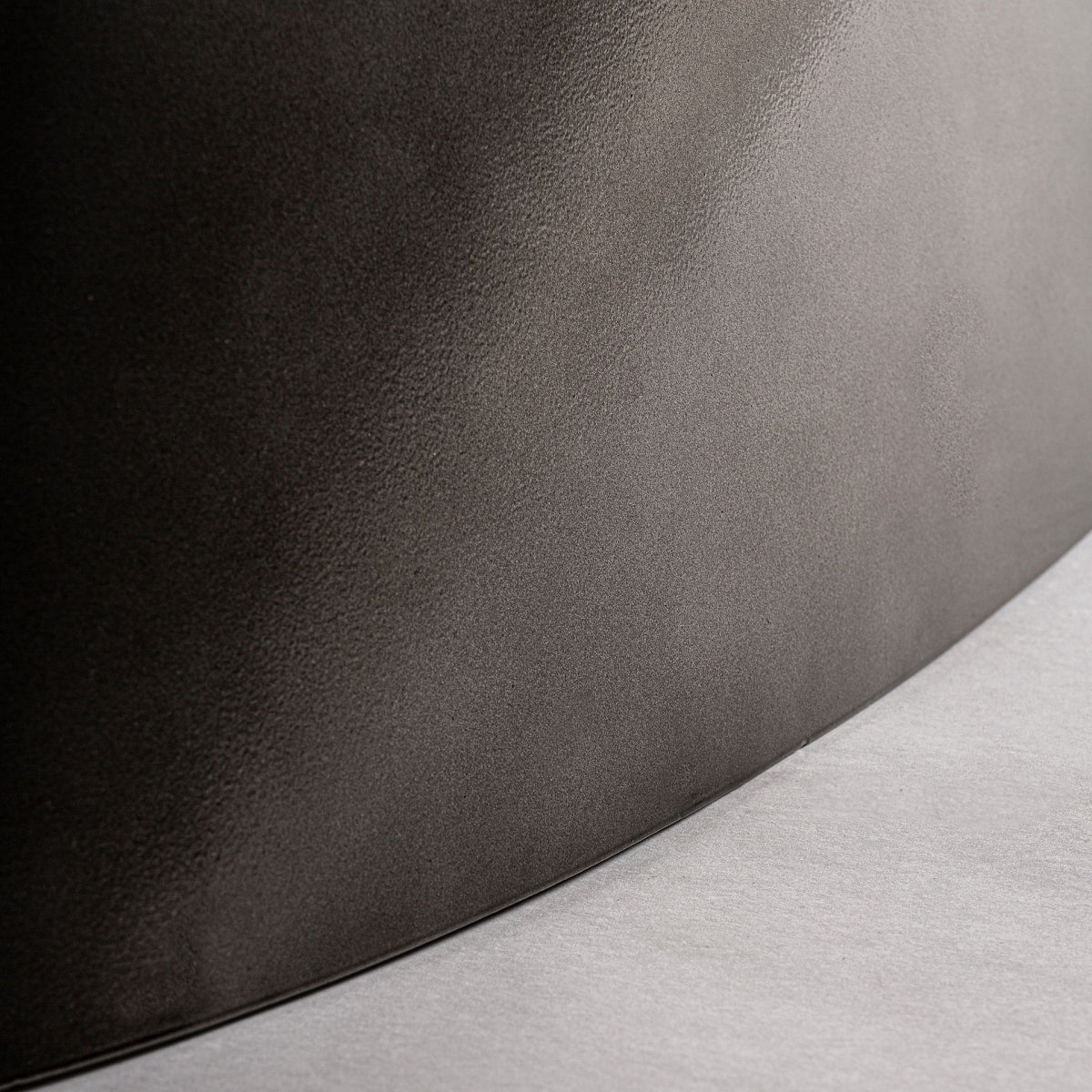 Primer plano de una superficie curva y texturizada similar a un diseño art déco, con una transición de oscuro a claro como la elegante veta de la madera de mango en la Mesa de comedor rectangular en madera y acero Warhem.