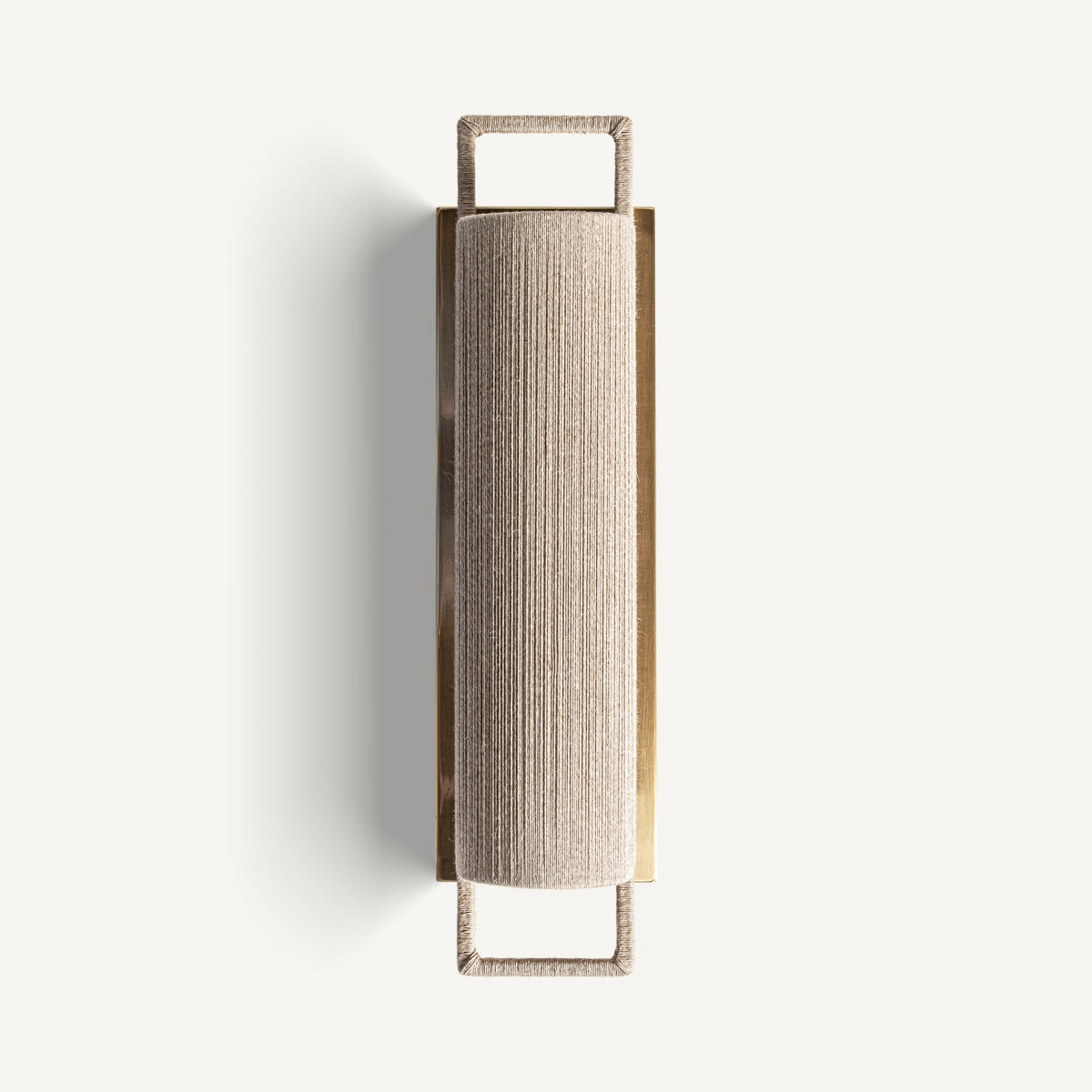 El Aplique de pared en hierro y cuerda Rives S presenta una pantalla texturizada cilíndrica y un marco de hierro resistente, que ofrece un toque de diseño art déco, fotografiado sobre un fondo blanco liso.