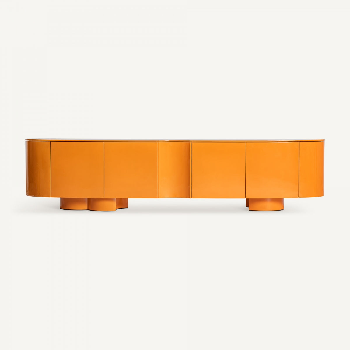 Elegante y moderno Mueble TV en madera DM y hierro Mirkov en un llamativo naranja con un acabado lacado naranja. Presenta curvas suaves y patas circulares elevadas, personificando el diseño minimalista sobre un fondo blanco liso.