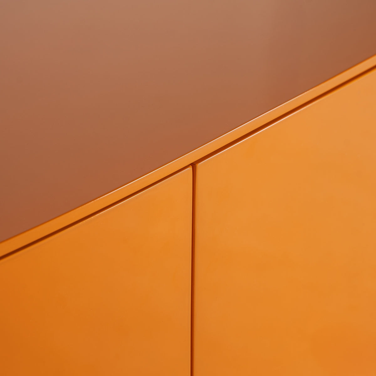 Primer plano de un rincón de mueble naranja y marrón con superficies lisas y brillantes, destacando su acabado lacado naranja. Su diseño minimalista recuerda la elegancia de un Mueble TV en madera DM y hierro Mirkov.