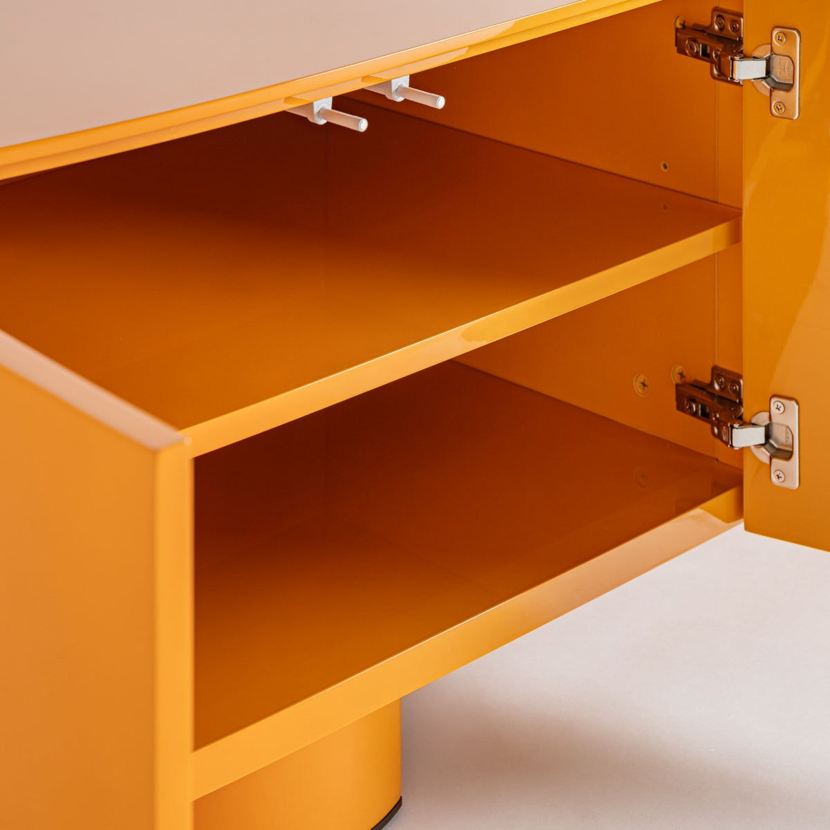 Mueble de TV Mirkov naranja abierto con dos puertas, bisagras metálicas y un estante interior sobre un suelo claro. Su diseño minimalista se complementa con un vibrante acabado lacado naranja, que le aporta un toque elegante.