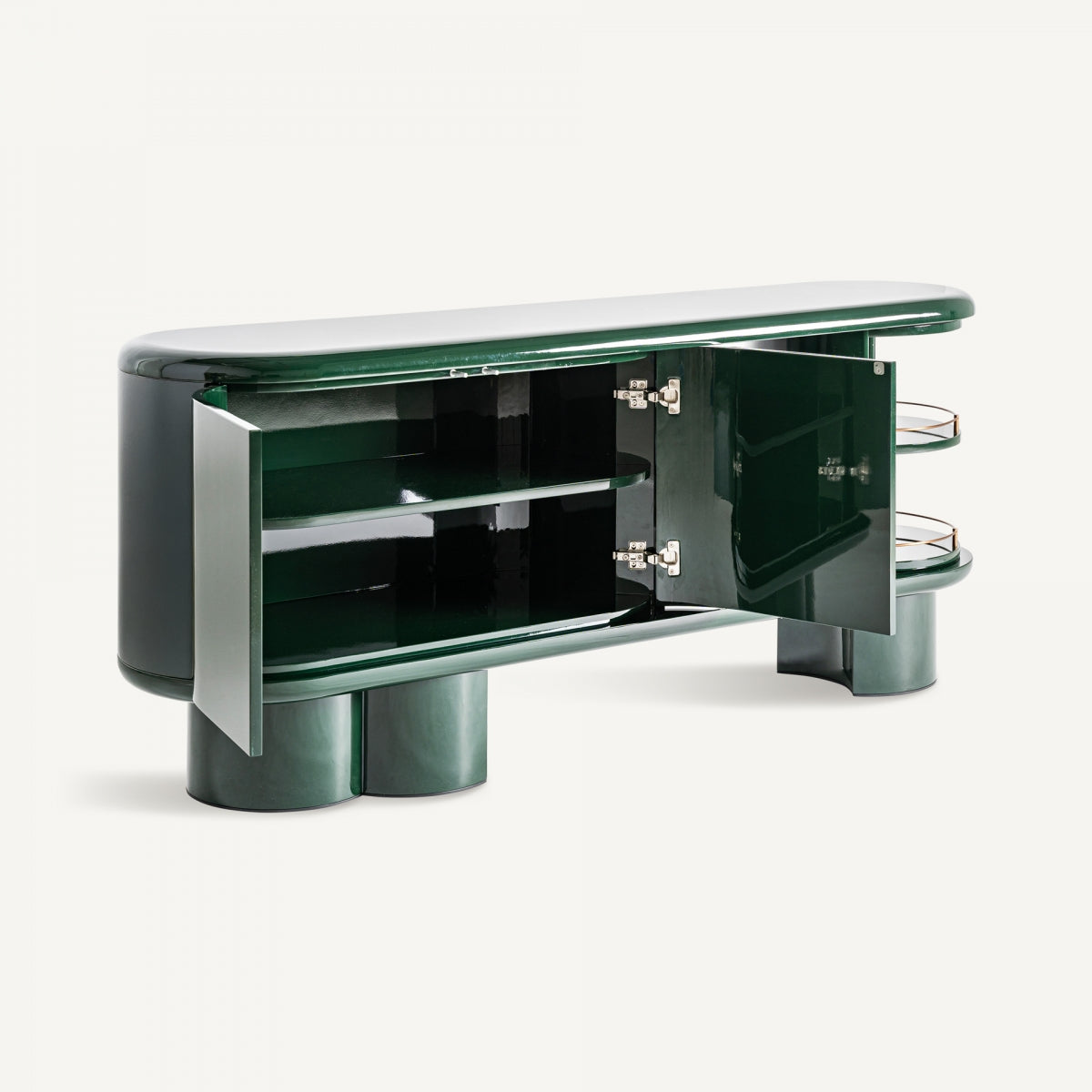 El Aparador en DM verde y acero inoxidable Gory (180x45 cm) presenta un acabado verde oscuro brillante, bordes redondeados, puertas de gabinete abiertas, estantes interiores y patas cilíndricas: una pieza de inspiración Art Deco ideal para quienes buscan muebles exclusivos.