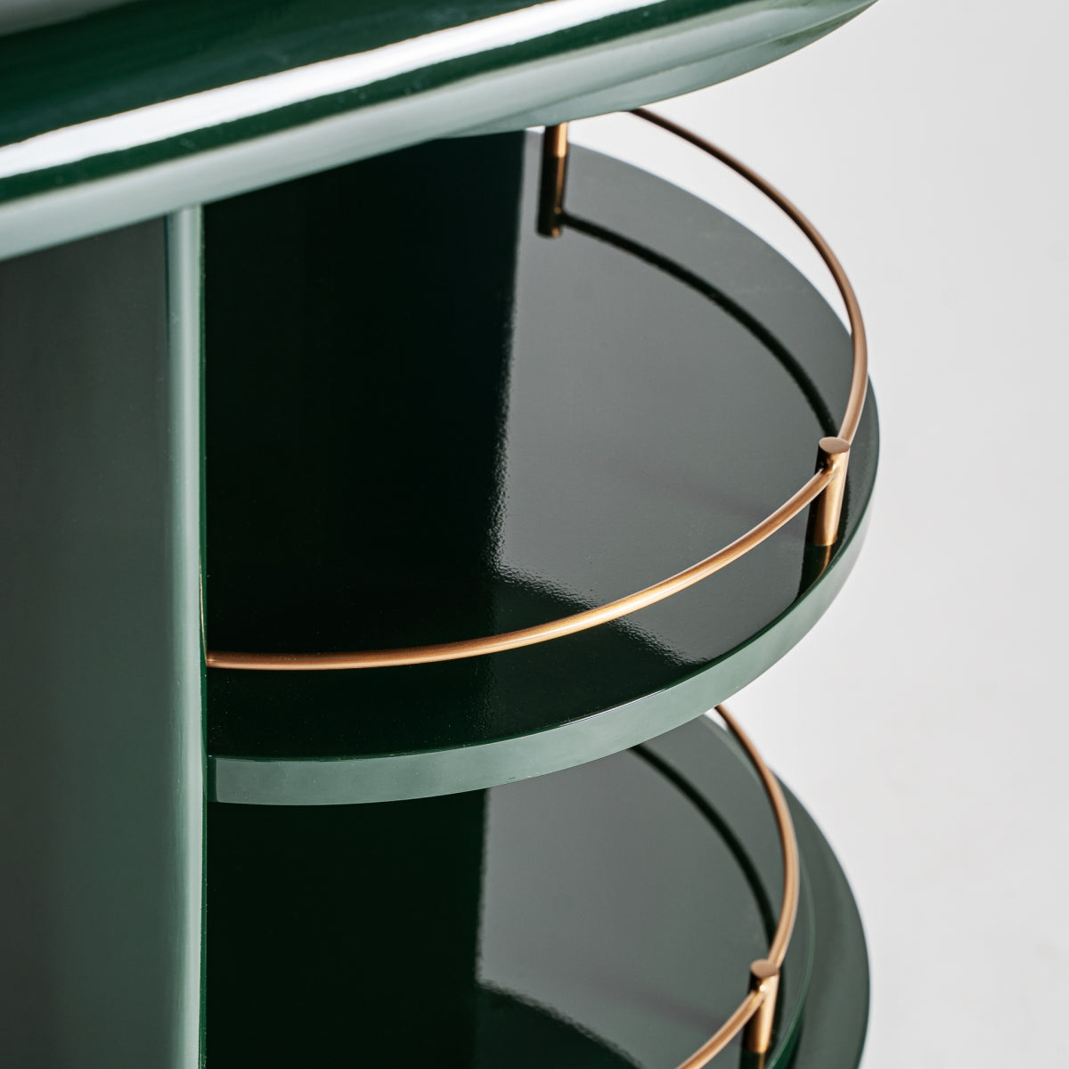 Primer plano del Aparador en DM verde y acero inoxidable (180x45 cm) Gory, una estantería brillante de inspiración Art Decó con barandillas doradas, ideal para añadir muebles exclusivos a cualquier espacio.