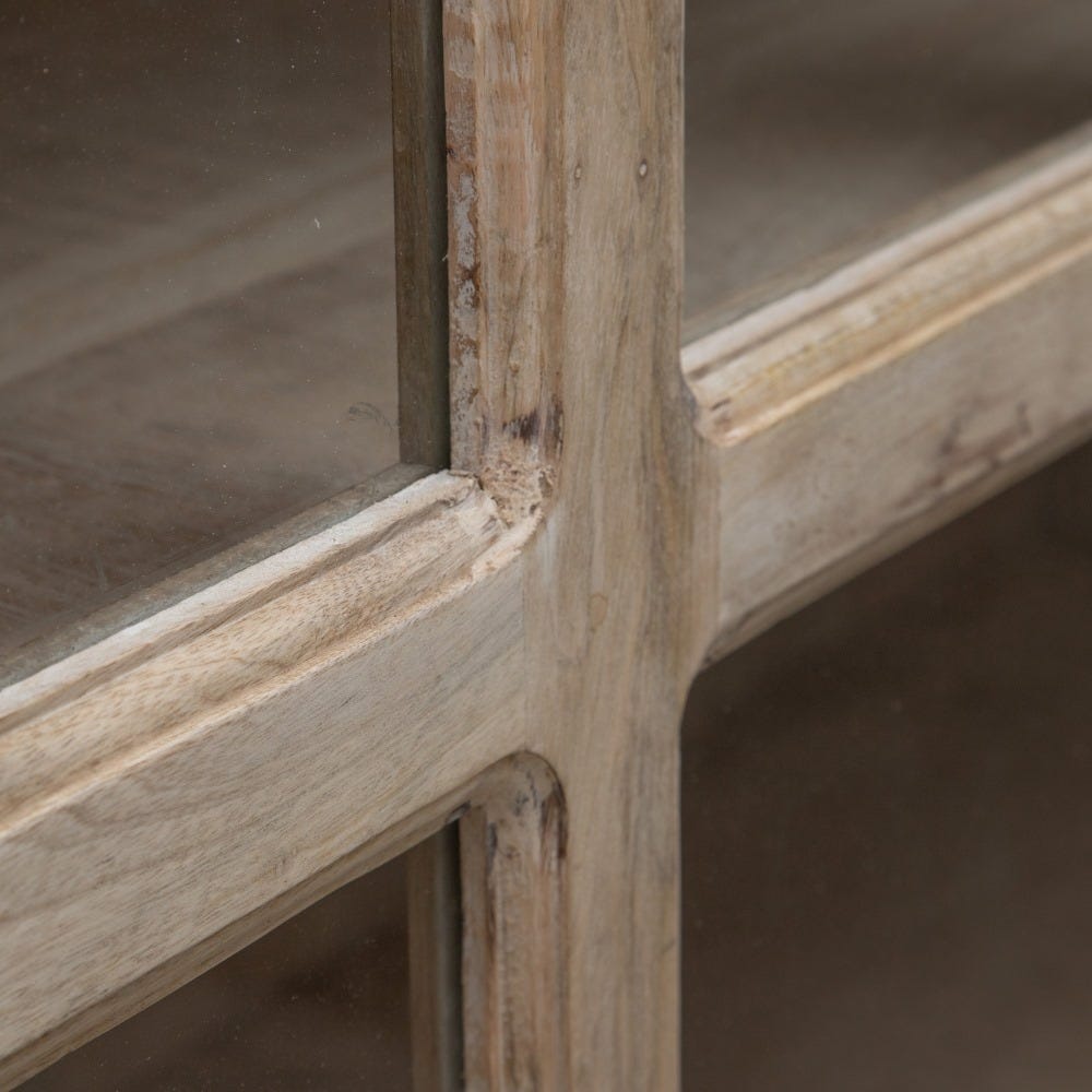 Primer plano de una esquina de madera en un mueble con acabado desgastado, que muestra el diseño rústico de la Vitrina Alta Natural Blanco Rozado, elaborada en madera de mango.