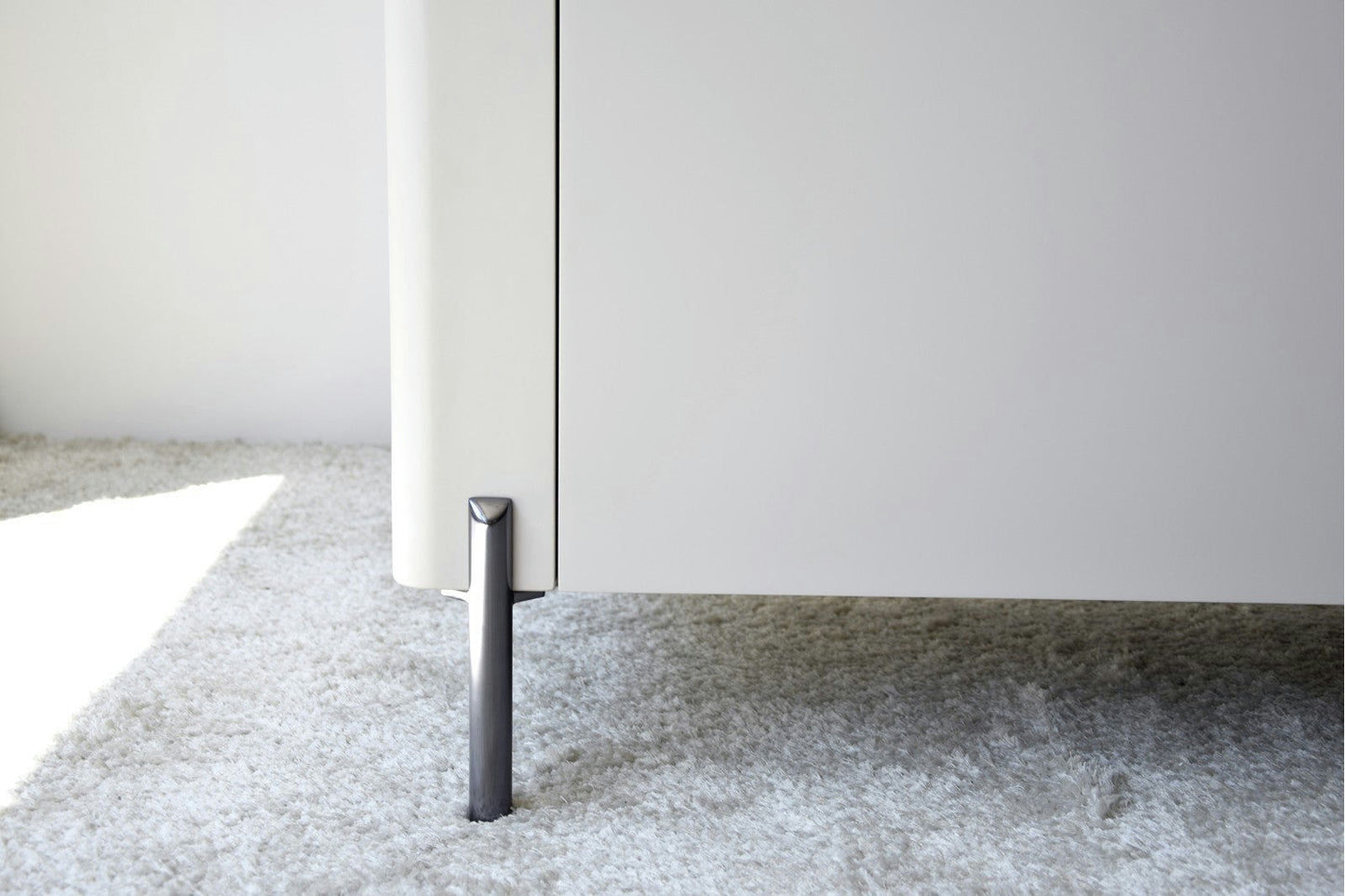 El Aparador bajo Gris Arena y Madera de Roble Elegance con patas de metal se asienta elegantemente sobre una alfombra gris claro, mostrando un diseño moderno.