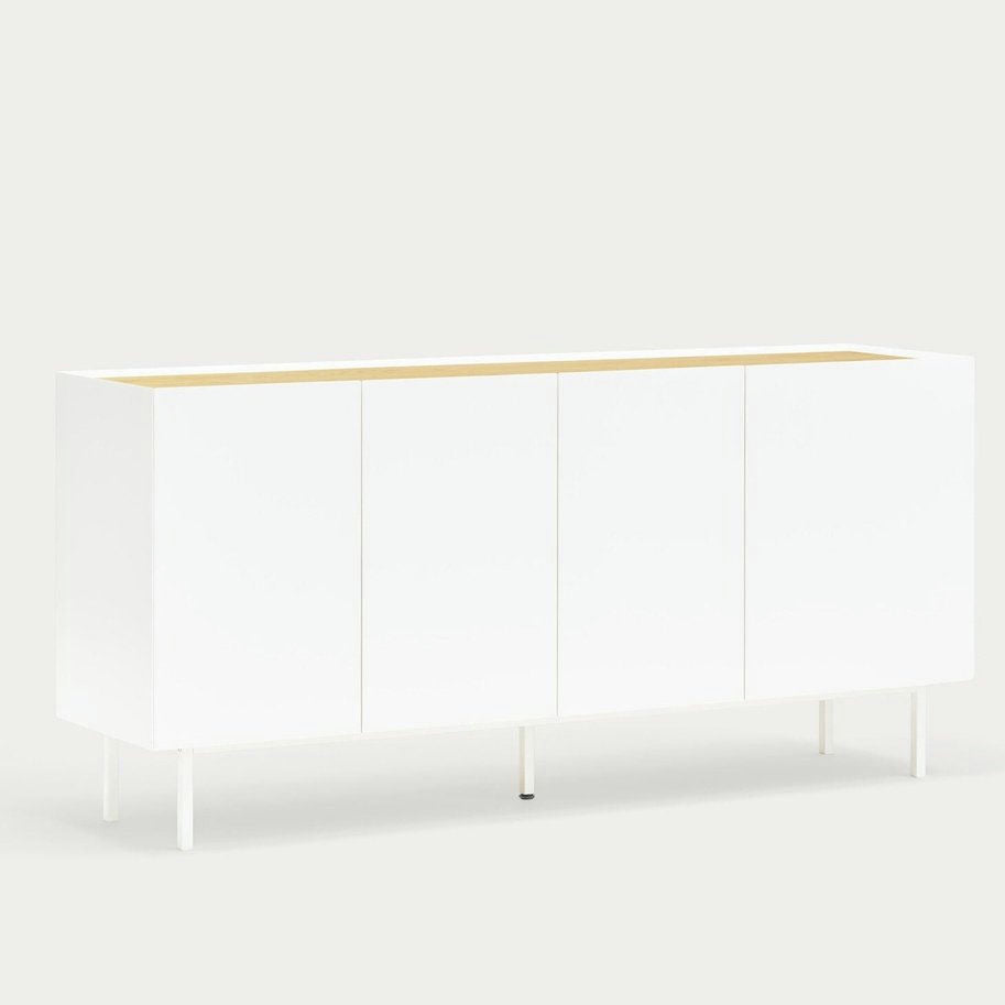 El Aparador bajo con Puertas Arista 4P3C es un aparador minimalista blanco con cuatro puertas y patas delgadas, que ofrece almacenamiento versátil sobre un fondo gris claro.