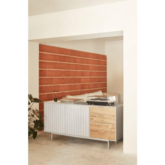 Elegancia Moderna define este espacio con el Aparador bajo en madera y DM Sierra 2P4C que cuenta con un tocadiscos y libros. La pared texturizada que imita el ladrillo agrega profundidad, mientras que una planta en maceta reposa con gracia sobre el piso beige.