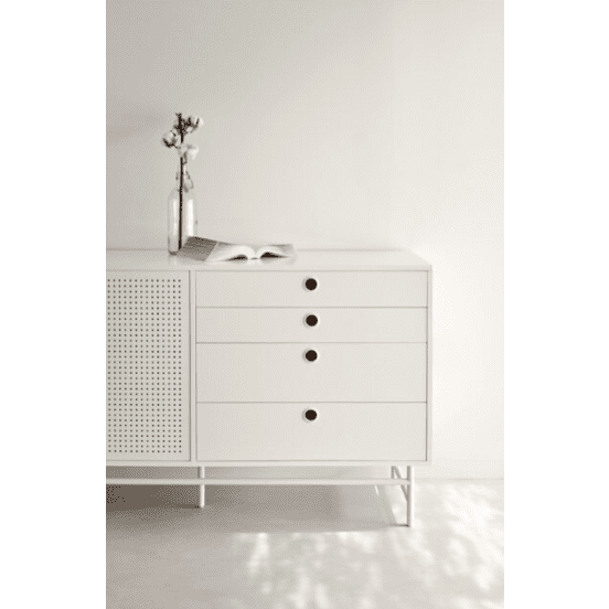 El Aparador en Metal y DM Punto 2P8C, un aparador minimalista blanco con tiradores circulares, se apoya contra una pared lisa y rezuma un diseño industrial moderno. Un jarrón y un libro abierto descansan elegantemente sobre la parte superior, lo que añade encanto a esta elegante pieza de almacenamiento versátil.