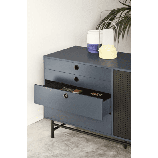 El Aparador en Metal y DM Punto 2P8C hace alarde de un almacenamiento funcional con un cajón abierto que revela un libro titulado