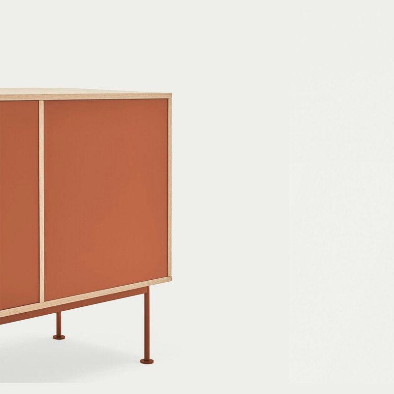 El aparador moderno Yoko 2P3C presenta un diseño industrial moderno con un marco de madera clara, puertas anaranjadas y patas delgadas de color naranja, que brindan un almacenamiento eficiente sobre un fondo blanco liso.