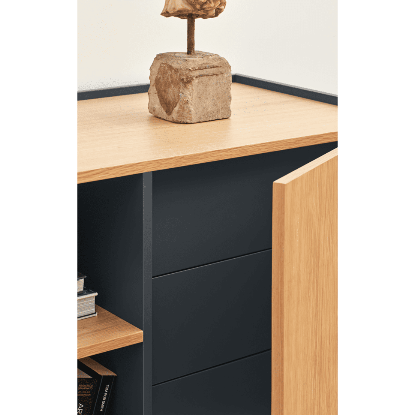 El Aparador moderno pequeño Otto 2P3C es una pieza de madera con una puerta abierta que revela estantes para un almacenamiento organizado, rematado con una escultura de piedra que combina funcionalidad con diseño contemporáneo.