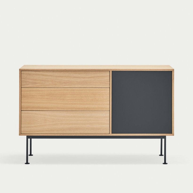 El Aparador moderno pequeño Yoko 1P3C es un aparador de madera con un diseño minimalista, que cuenta con tres cajones en el lado izquierdo y un gabinete en el lado derecho de color negro sobre delgadas patas de metal negro para un almacenamiento eficiente.