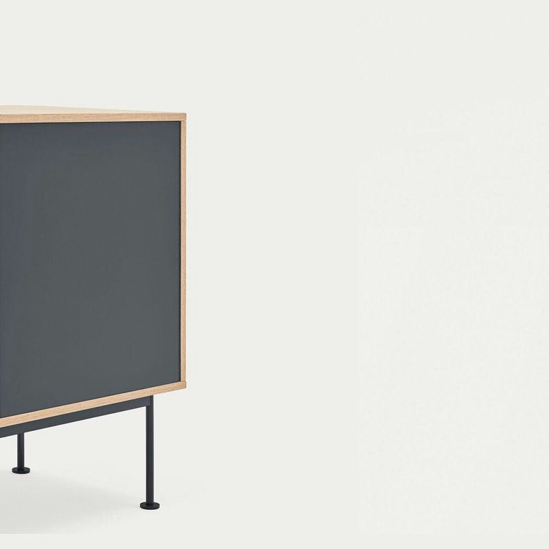 El aparador moderno pequeño Yoko 1P3C presenta un diseño minimalista con una puerta oscura, un marco de madera clara y patas negras delgadas. Su diseño moderno ofrece almacenamiento eficiente mientras se destaca elegantemente sobre un fondo liso.