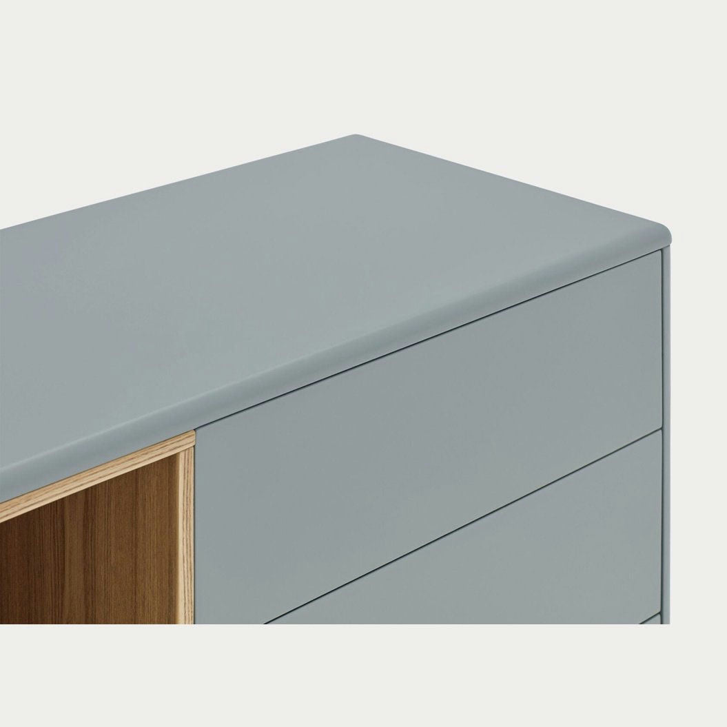 El Aparador pequeño con Cajones Corvo 1P3C es un gabinete gris claro moderno y minimalista con bordes suaves, tres cajones y una sección de estante de madera abierta, ideal para quienes buscan un diseño escandinavo en un aparador compacto.