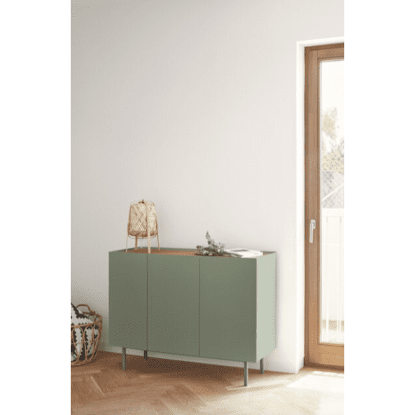 Una habitación minimalista presenta el Aparador pequeño con Puertas Arista 3P3C adornado con elementos decorativos, colocados junto a una puerta de vidrio con marco de madera, que encarna el diseño contemporáneo.