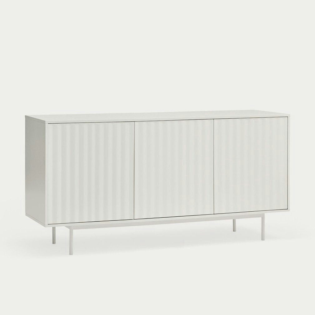 El Aparador pequeño con Puertas Sierra 3P3C es un aparador blanco minimalista con tres puertas con paneles y patas delgadas, que proporciona Almacenamiento Ordenado sobre un fondo claro en cualquier espacio.