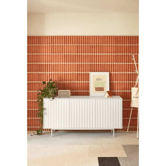 El Aparador pequeño con Puertas Sierra 3P3C irradia un encanto industrial moderno contra la pared con diseño de ladrillos rojos, realzada por obras de arte enmarcadas y una pequeña planta. La alfombra en tonos neutros complementa este ambiente elegante, ofreciendo tanto elegancia como estilo.