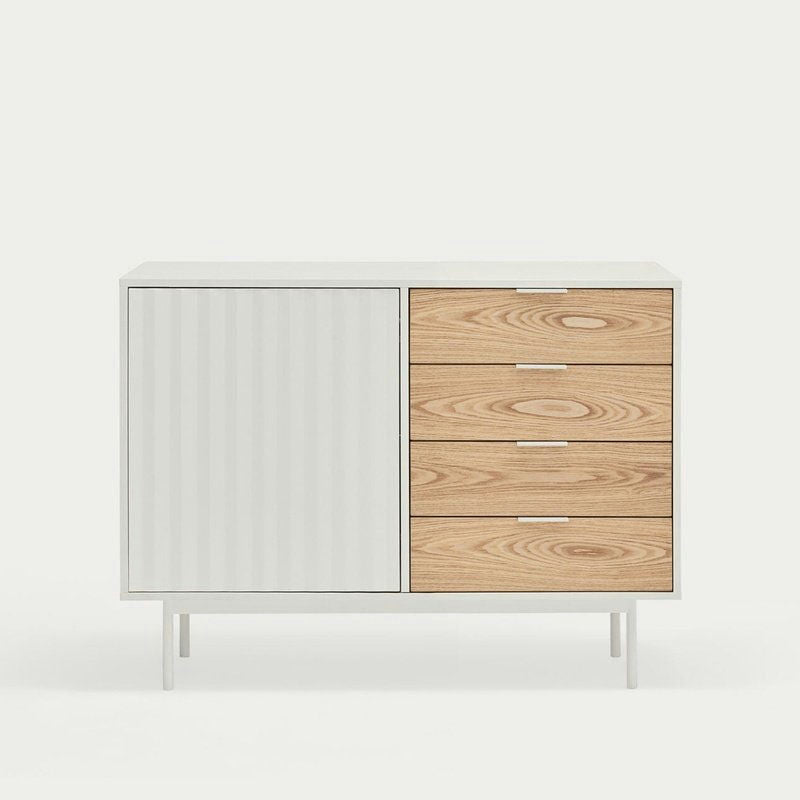El Aparador pequeño en Madera y DM Sierra 1P4C combina un moderno diseño asimétrico con una puerta blanca a la izquierda, cuatro cajones de madera a la derecha y se apoya elegantemente sobre delgadas patas blancas para soluciones de almacenaje con estilo.