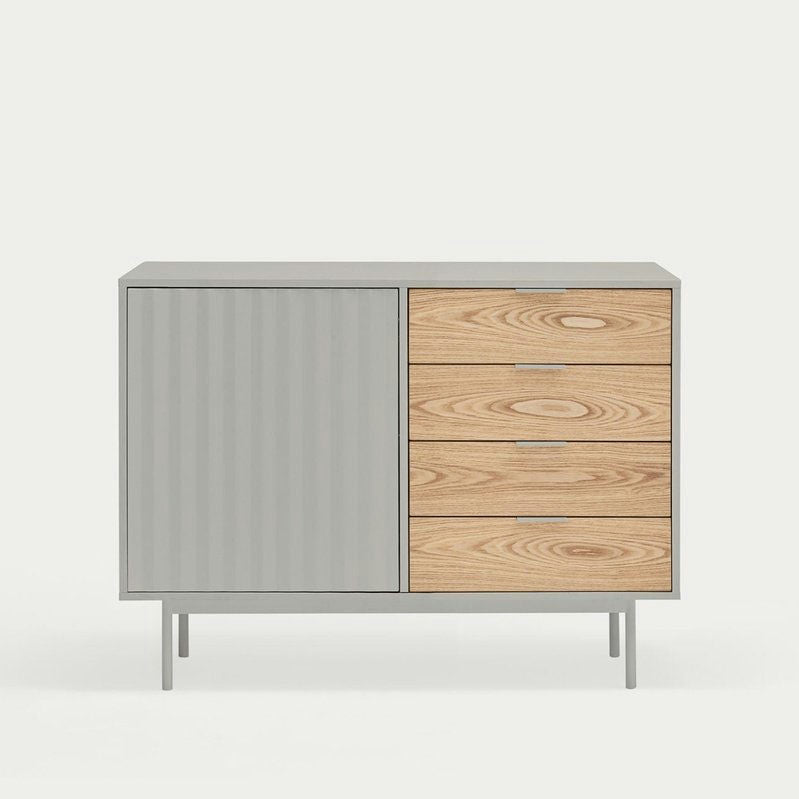 El Aparador pequeño en Madera y DM Sierra 1P4C ofrece elegantes soluciones de almacenamiento con un diseño minimalista gris, presentando un estilo asimétrico con una puerta vertical texturizada a la izquierda y tres cajones de madera a la derecha.