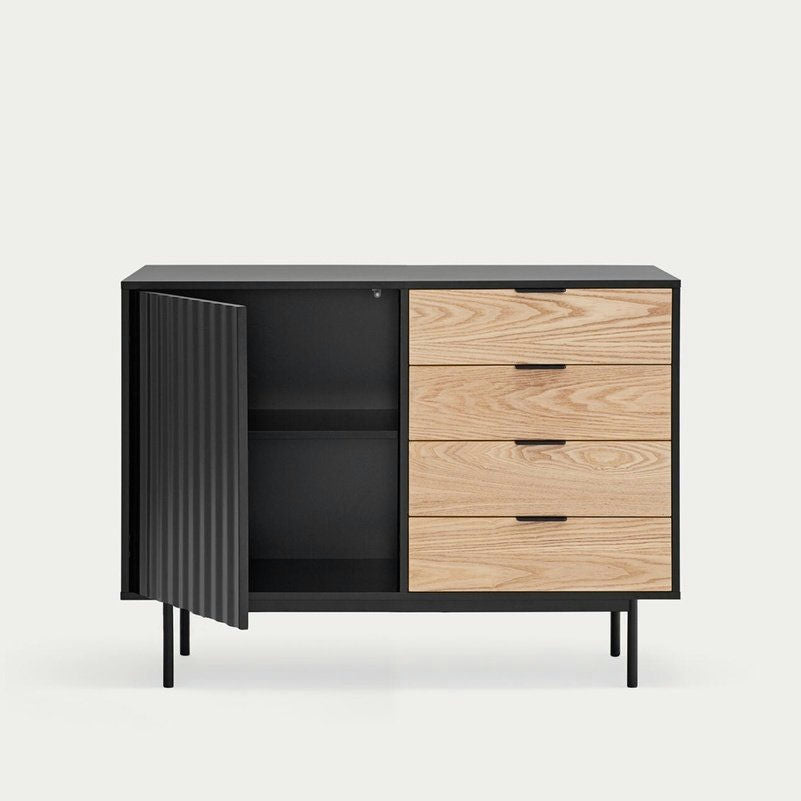 El Aparador pequeño en Madera y DM Sierra 1P4C es un moderno mueble negro con un elegante diseño asimétrico, que ofrece soluciones de almacenaje con tres cajones de madera a la derecha y una puerta abierta que revela dos estantes a la izquierda.
