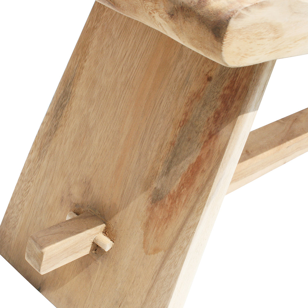 Primer plano de una unión de madera en la Banqueta en Madera de Meh Sate, resaltando la conexión entre la pata y el asiento elaborado a partir de madera maciza, con veta visible y espiga clavada para un auténtico diseño rústico.