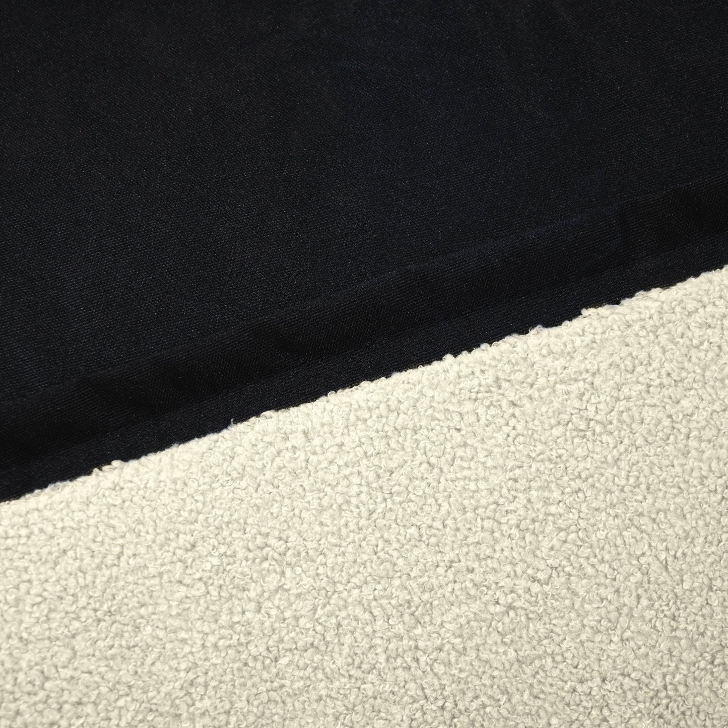 Un primer plano del Bean bag puff grande de tela borreguito 115×90×75 cm CLIP CLAP 115 TEDDY resalta su tejido oscuro contra una superficie clara y texturizada, mostrando el diseño moderno perfecto para cualquier salón, dormitorio o sala de juegos.