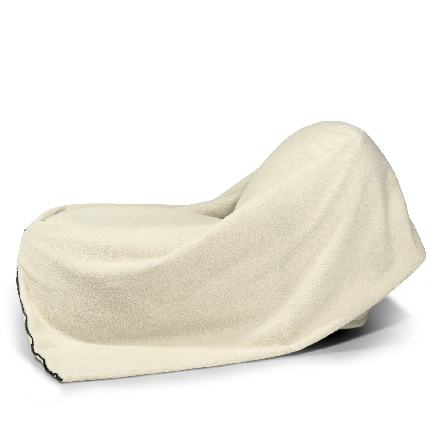 Un objeto grande, posiblemente un Bean bag puff de tela borreguito 100×55×60 cm - moderno - COCOON 100 TEDDY, está cubierto con una tela o manta de color crema que oculta su forma.