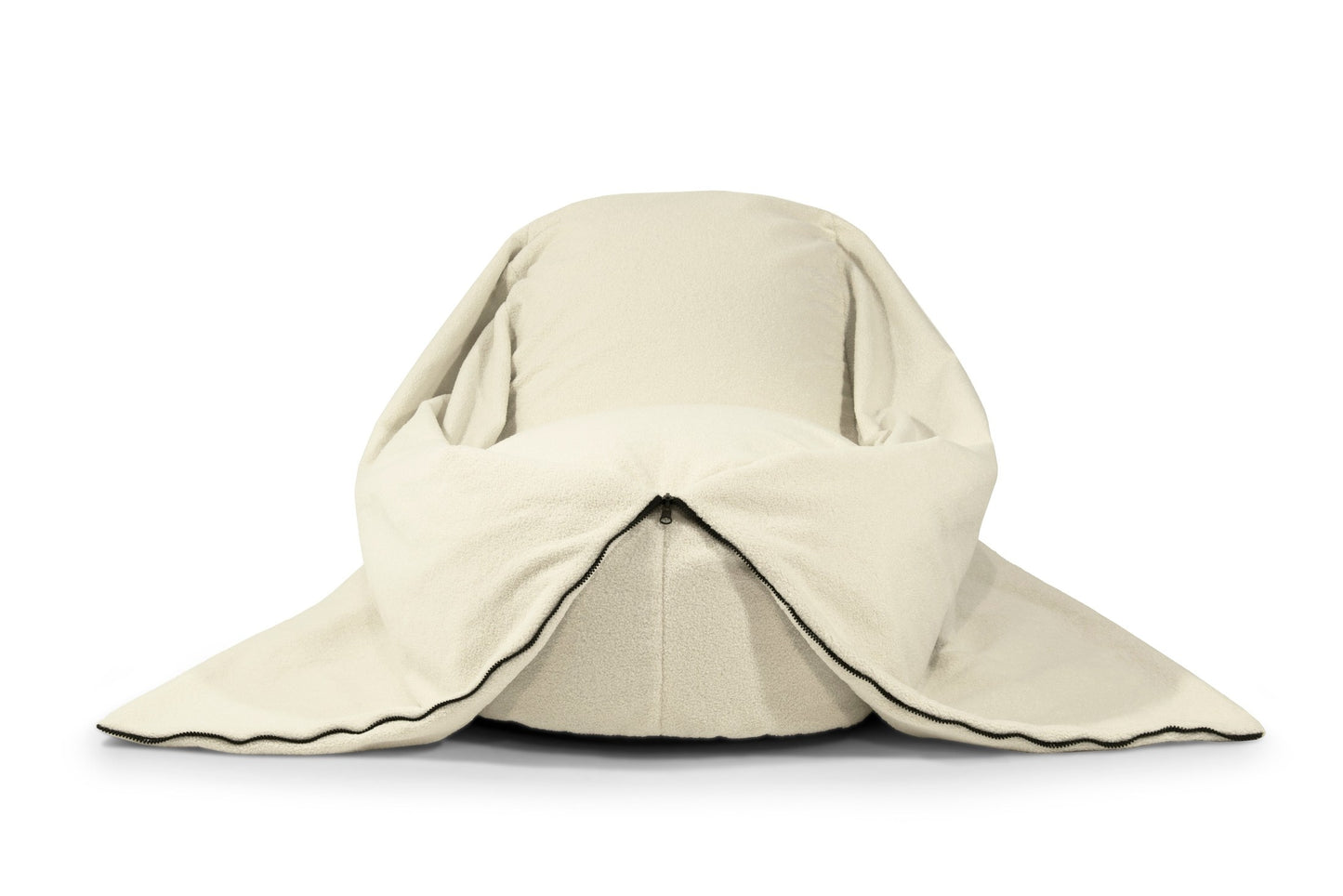 Un sillón beige con una manta drapeada a juego crea un look acogedor, perfecto para combinar con el puff de tela borreguito COCOON 120 TEDDY (120×60×65 cm) para realzar tu diseño moderno en cualquier salón, dormitorio o sala de juegos.