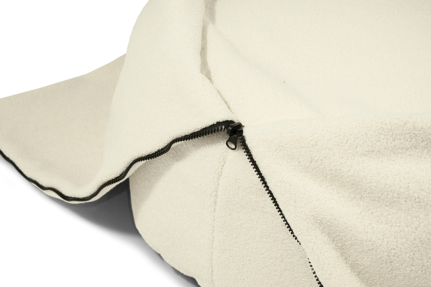 Detalle de la funda de borreguito beige del puff Bean bag COCOON 120 TEDDY (120×60×65 cm) con cremallera negra, parcialmente abierta para revelar su suave textura y moderno diseño para dormitorio, salón o sala de juegos.